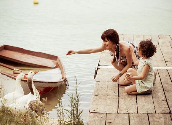 Woman And Girl Feeding Ducks