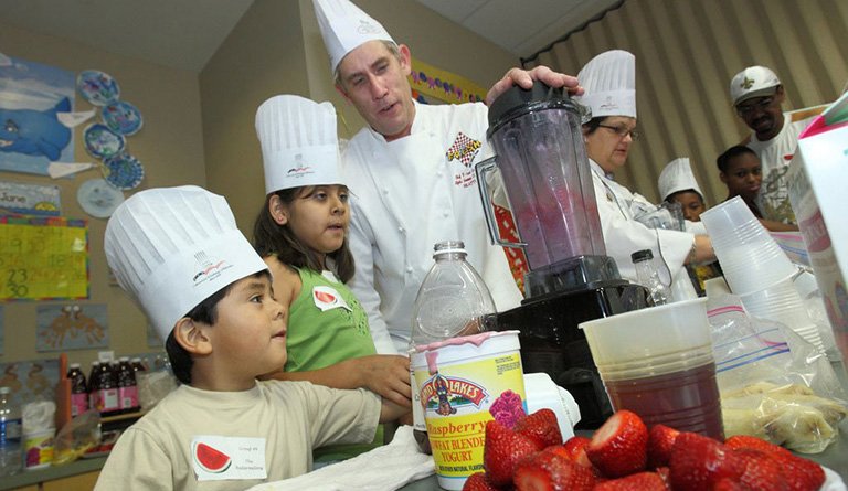 Kids Using Blender Alongside A Chef