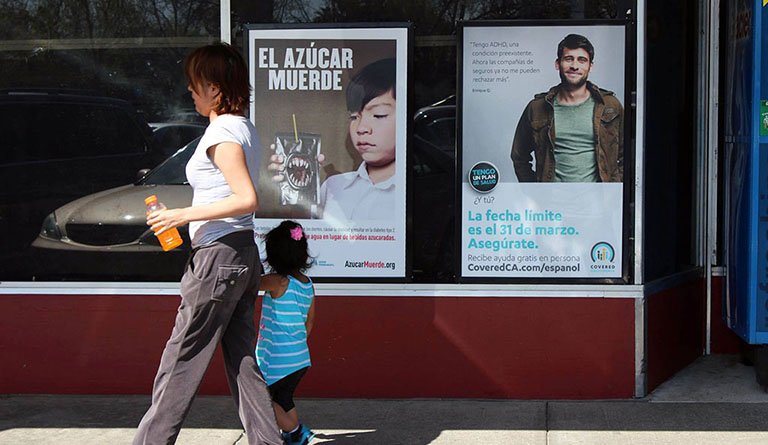 Mother And Daughter Walking By An Anti-Sugar Poster