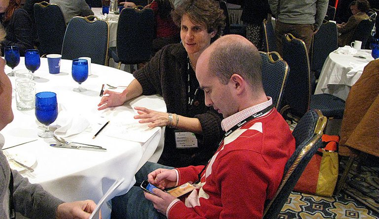 Man And Woman Sitting At A Conference