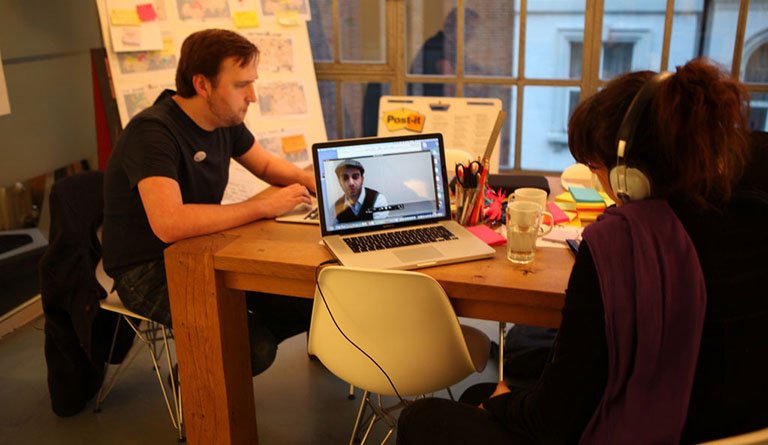 Man And Woman Sitting In Meeting Room On Laptops