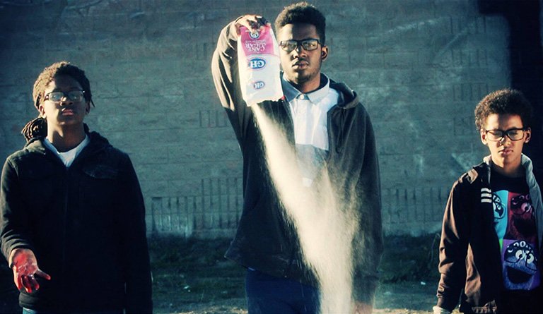 Teens Pouring Sugar Out Of Bag Onto The Pavement